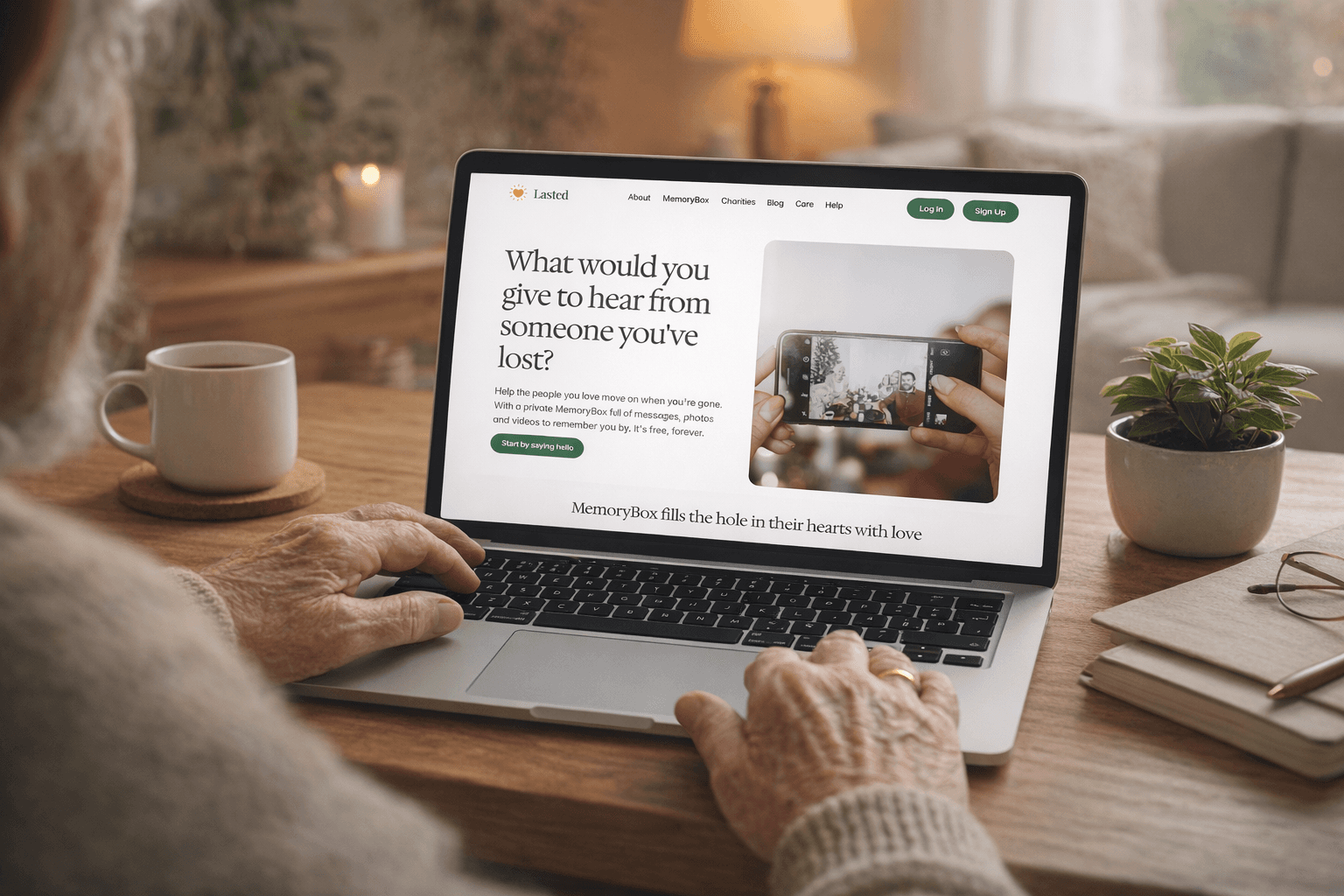 Elderly person using a laptop at home while browsing the Lasted website, which invites users to create a MemoryBox to record messages, photos and videos for loved ones.
