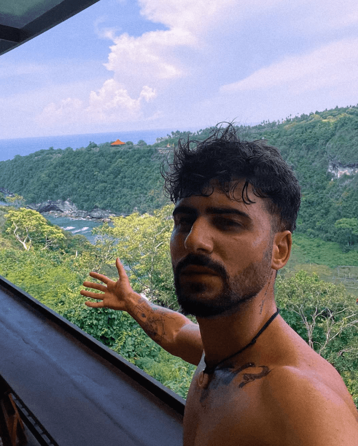 Professional portrait of a woman with blue eyes, dark brown hair, and a black blazer, set against a plain background.