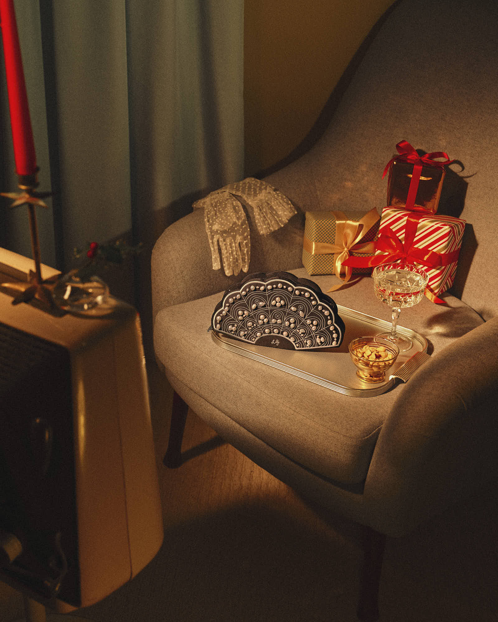 A cozy armchair with a blanket, a small stack of gifts, and a vintage television in warm, ambient lighting.