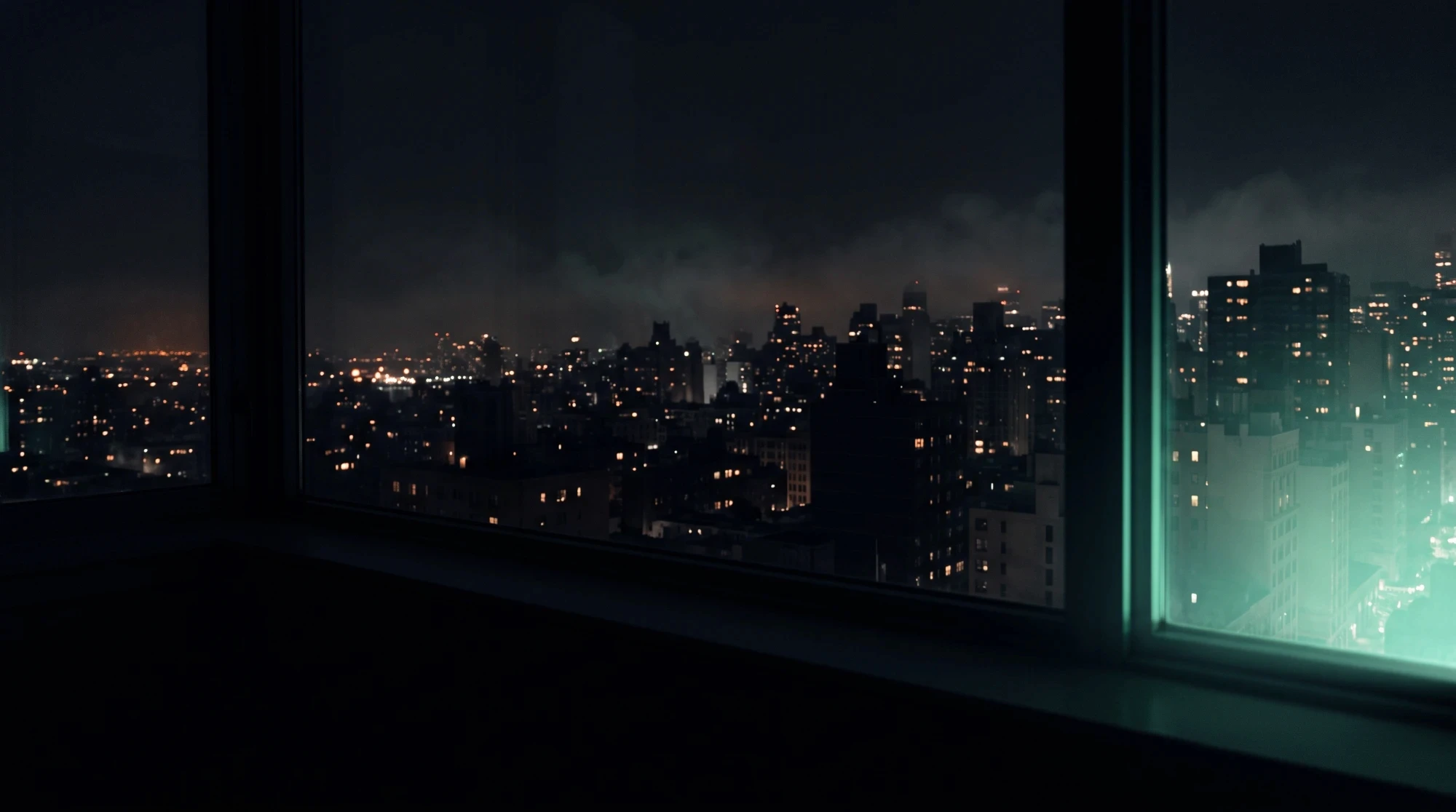 City skyline at night seen through a window, lit by a faint mint glow