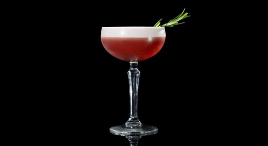 A closeup of a Pomegranate Cape Cod drink against a dark background.