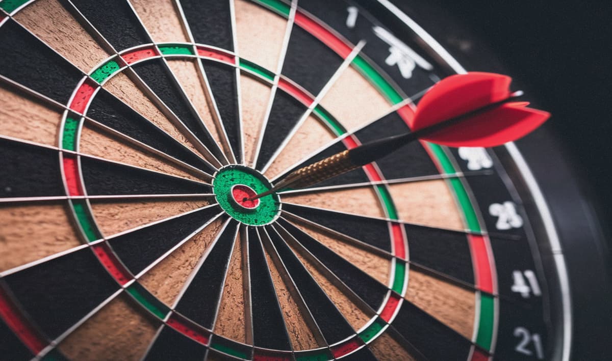 A dart sticking out of the bullseye on a darts board