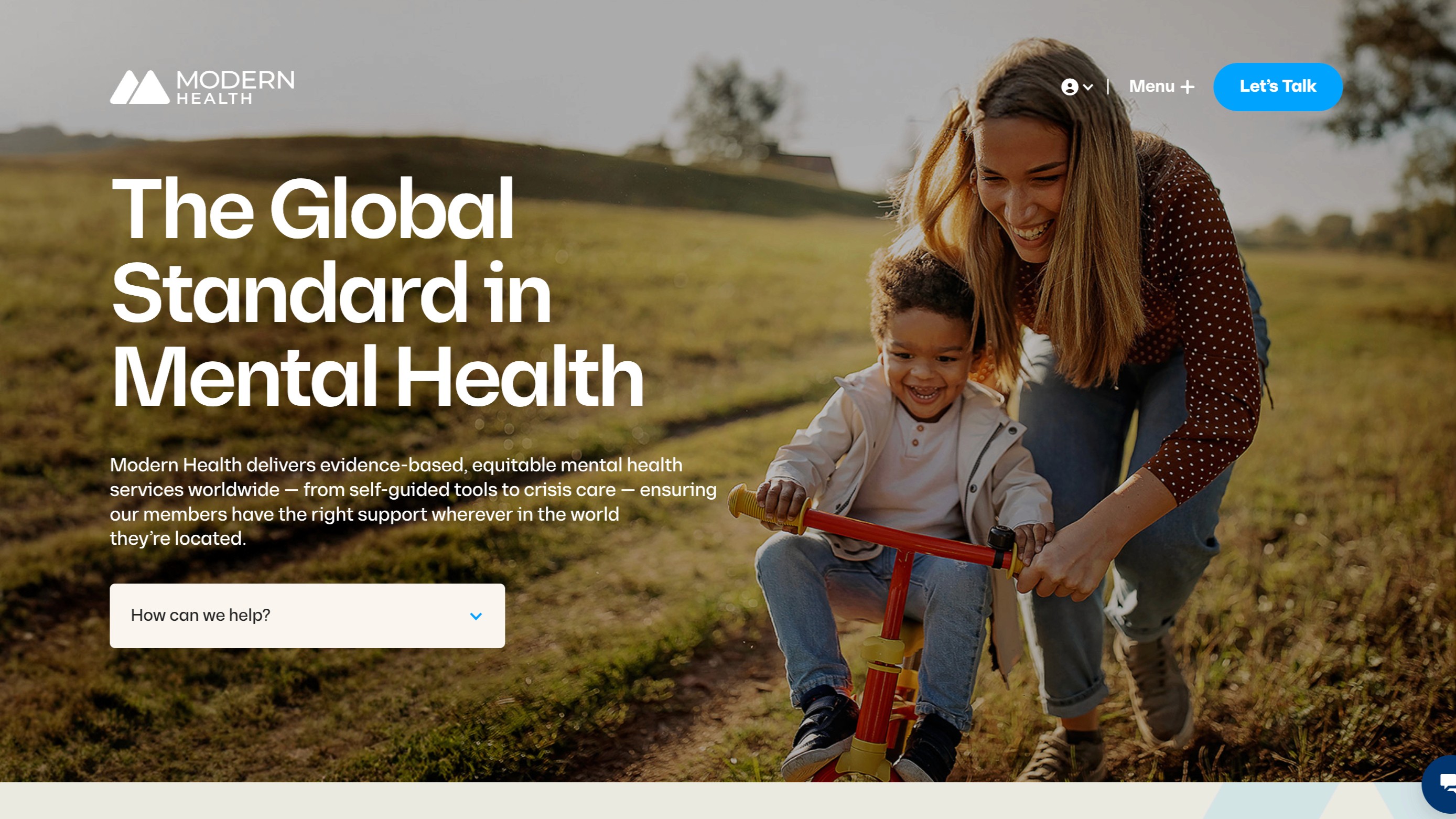 A hero section for Modern Health showing a sun-drenched outdoor photo of a woman helping a young child ride a tricycle. Large white text overlays the image: "The Global Standard in Mental Health." A search bar asks, "How can we help?"