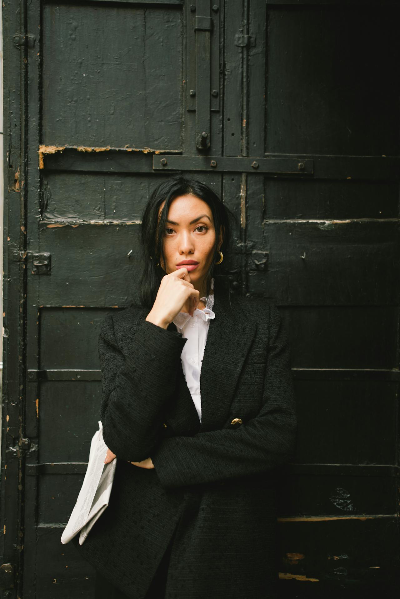 Portrait of a woman in front of a black door