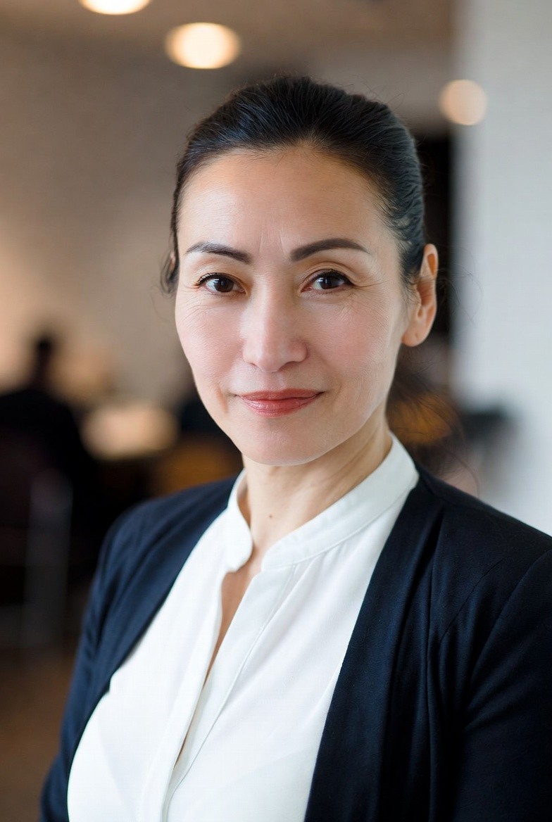 smiling woman wearing white and black pinstriped collared top