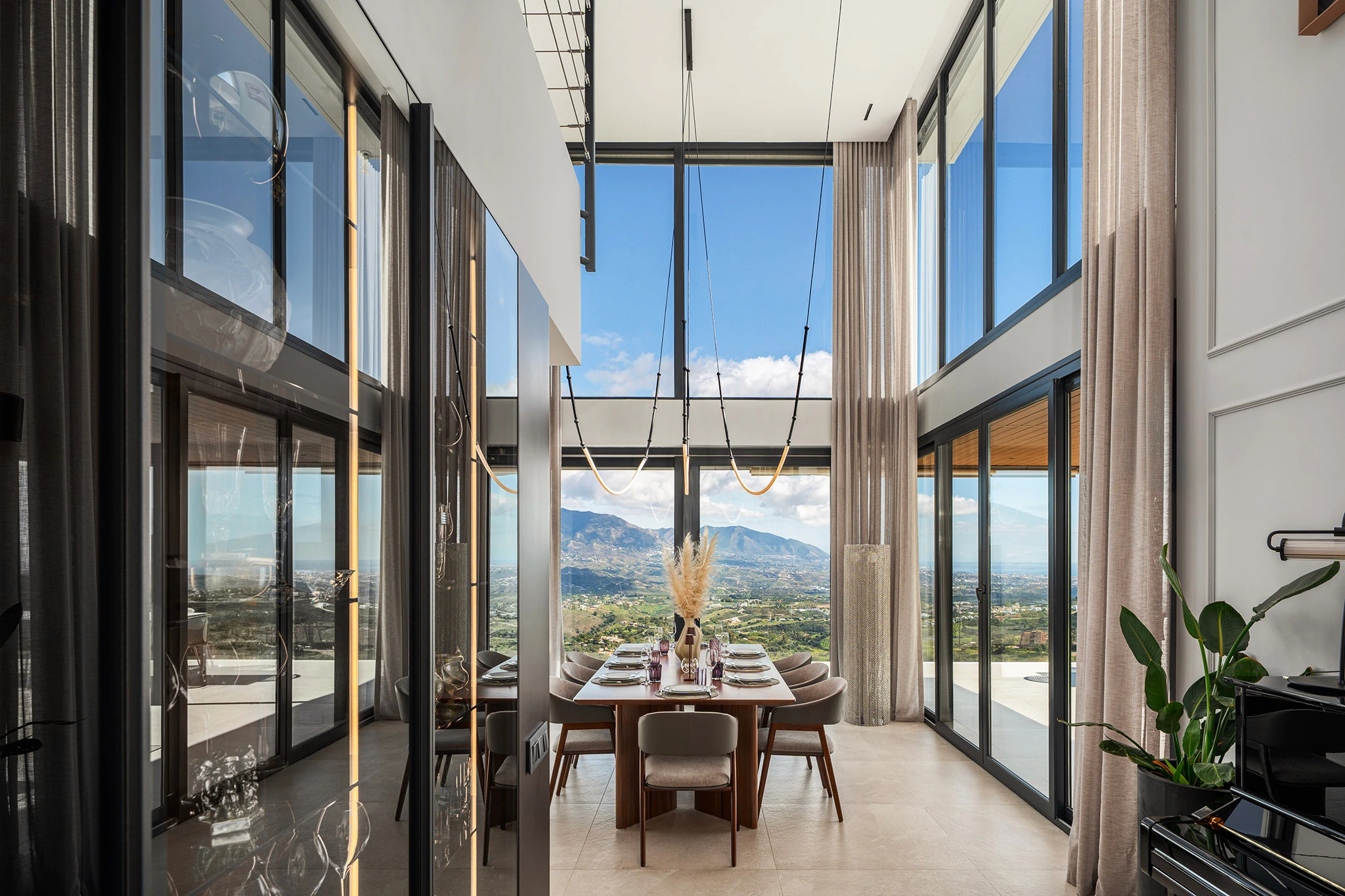 Villa Vista Marbella double-height dining area with panoramic glazing and mountain views