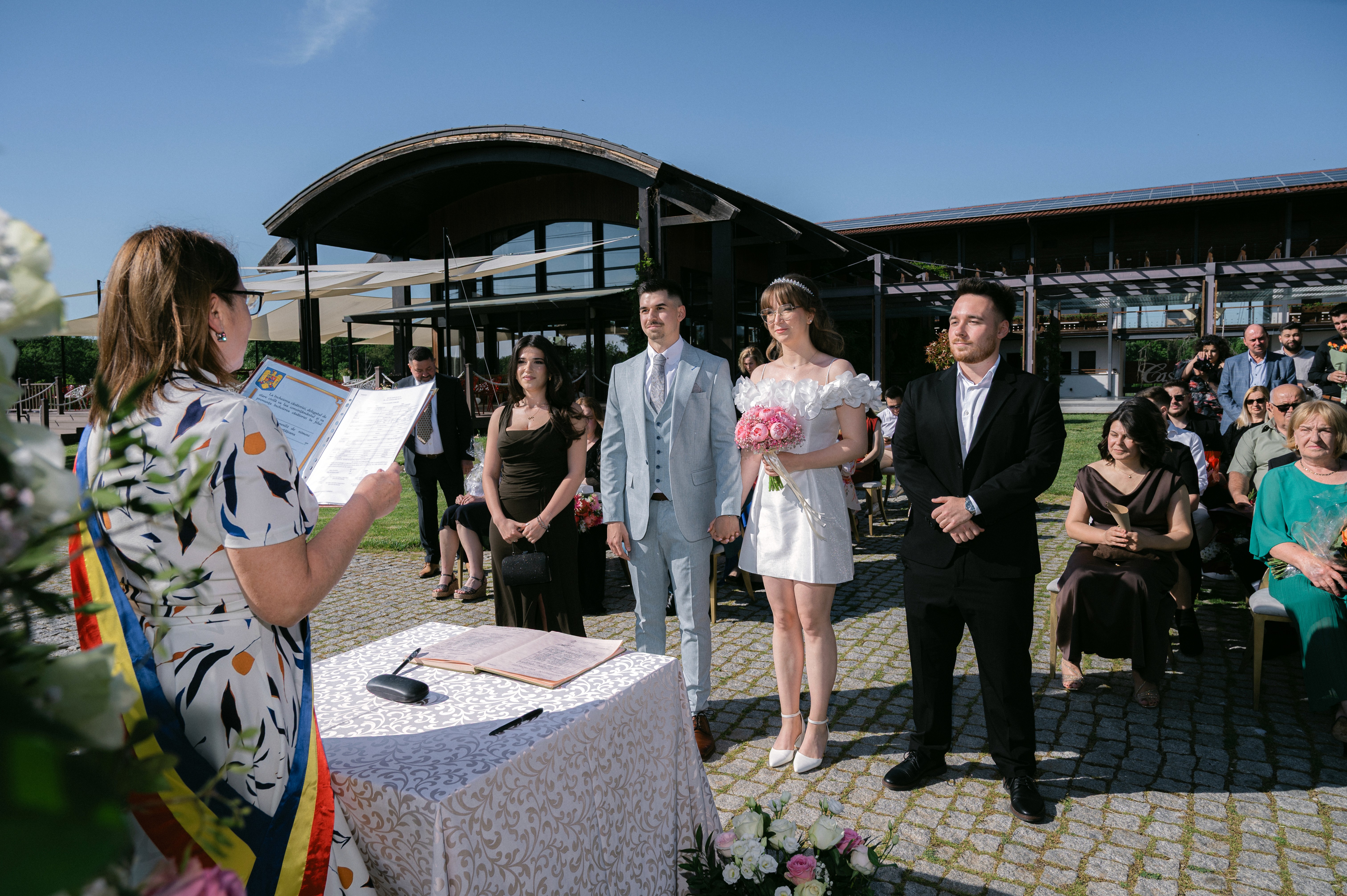 Ceremonie de cununie civilă în aer liber la Casa Vlăsiei, cu invitații adunați pe malul lacului într-o atmosferă elegantă și relaxată.