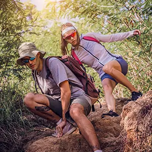 Couple hiking in a difficult trail in the hills of Colorado.