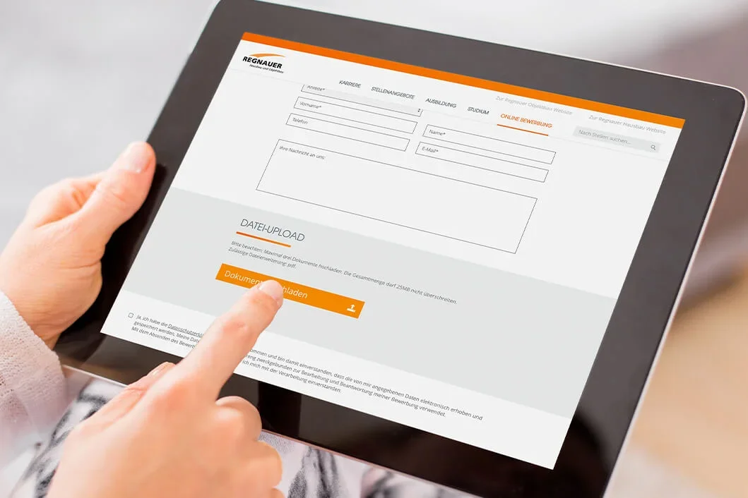 Finger tippt auf Schaltfläche zum Hochladen von Dokumenten auf einem Tablet-PC, ein Online-Bewerbungsformular ist sichtbar.