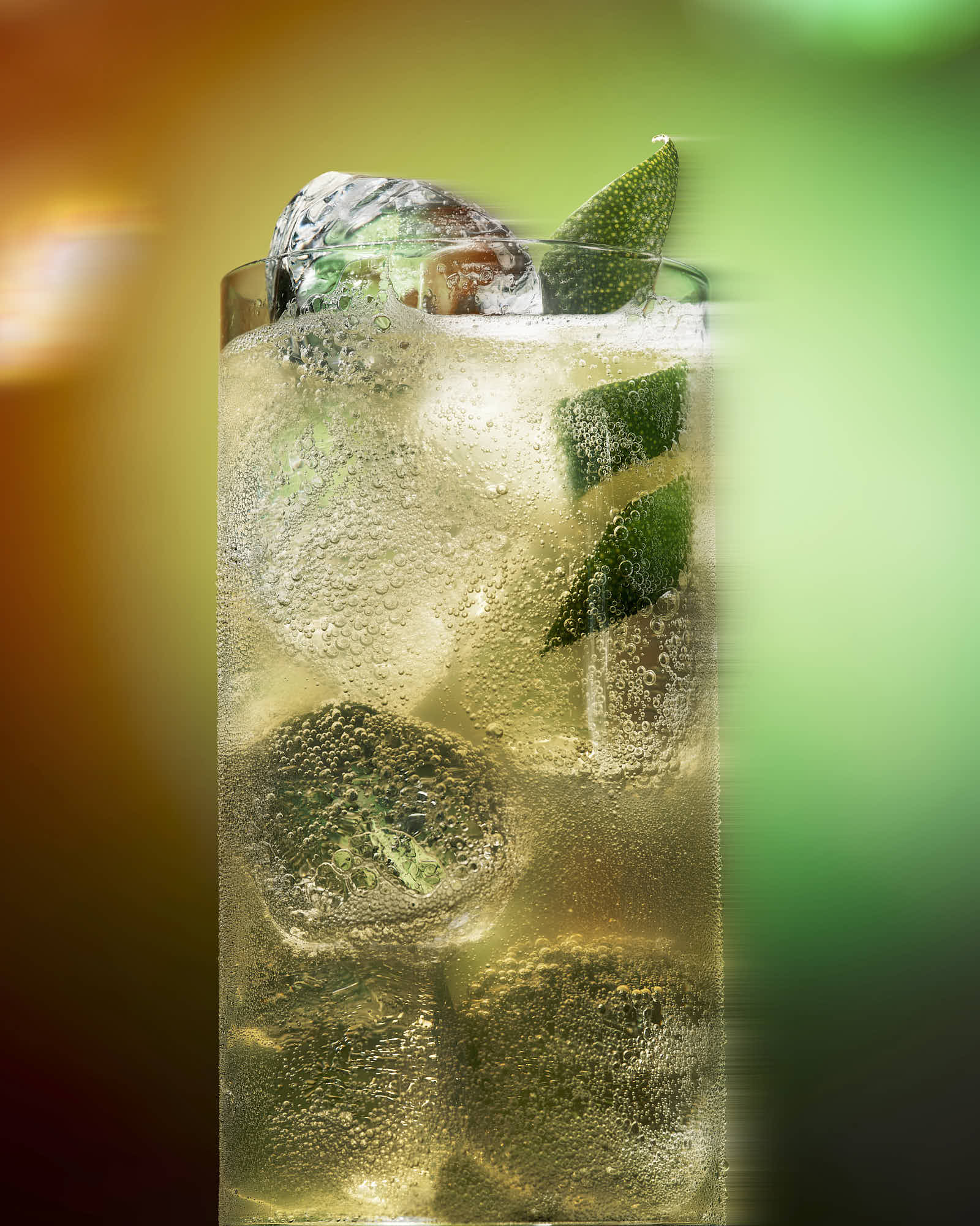 A refreshing drink with mint leaves and ice, set against a colorful blurred background.