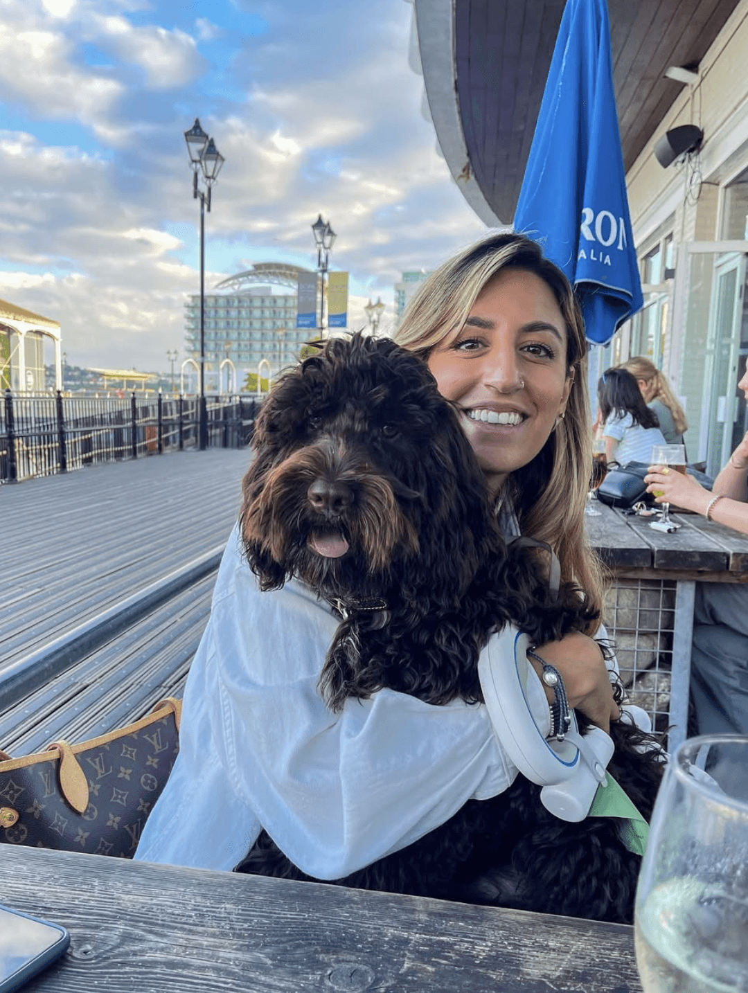 Close-up of two hands gently clasped, one wearing a sparkling engagement ring. The soft lighting and pastel nails evoke a sense of romance and intimacy.