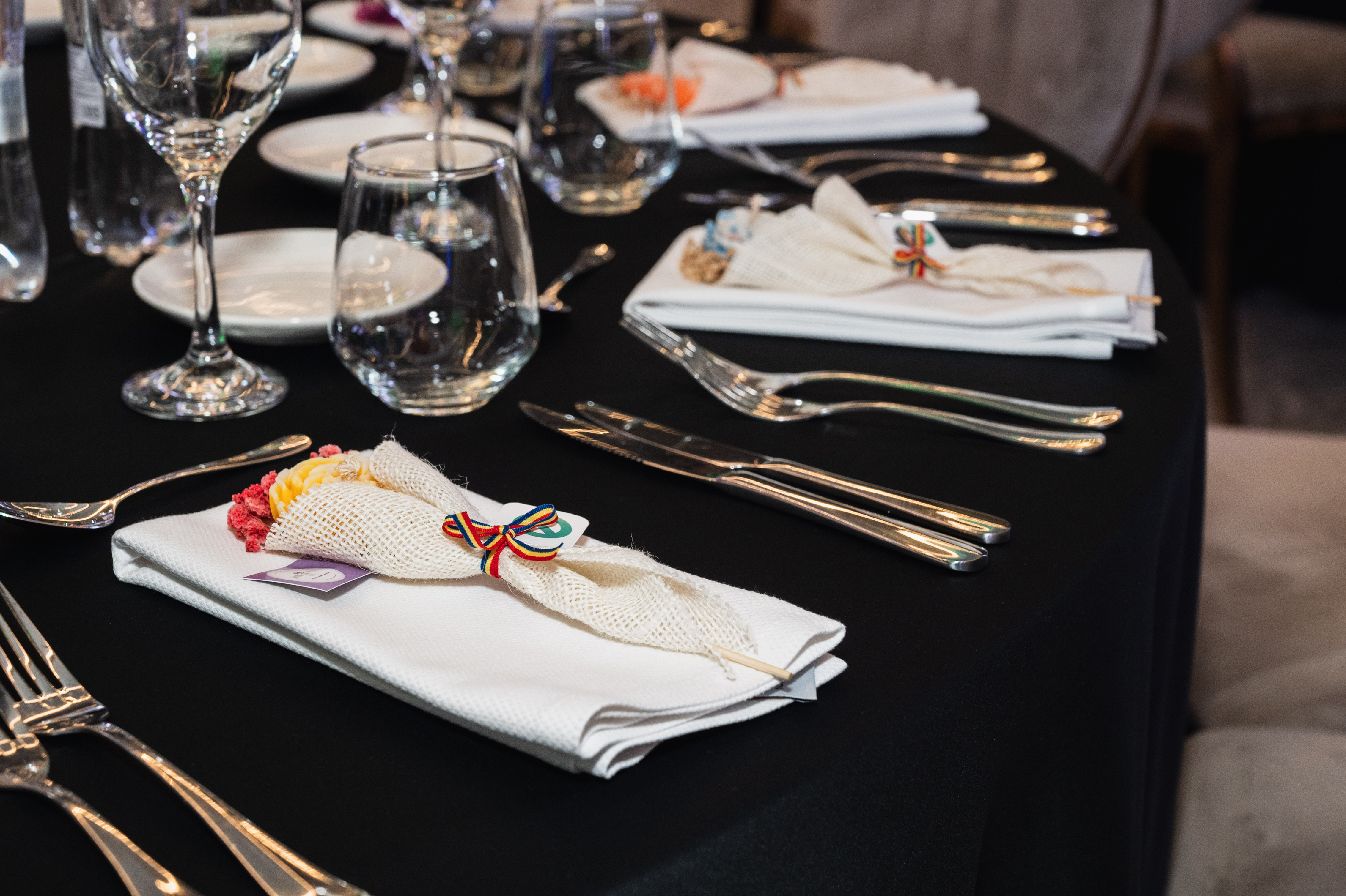 Mese aranjate pentru un eveniment corporate de amploare, iluminare ambientală verde — fotograf corporate București.