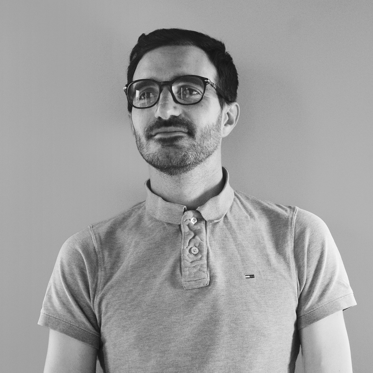 Portrait of a laughing person with curly hair wearing a white shirt