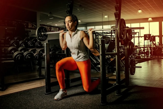 Woman training with weights in a gym, focused on strength and movement