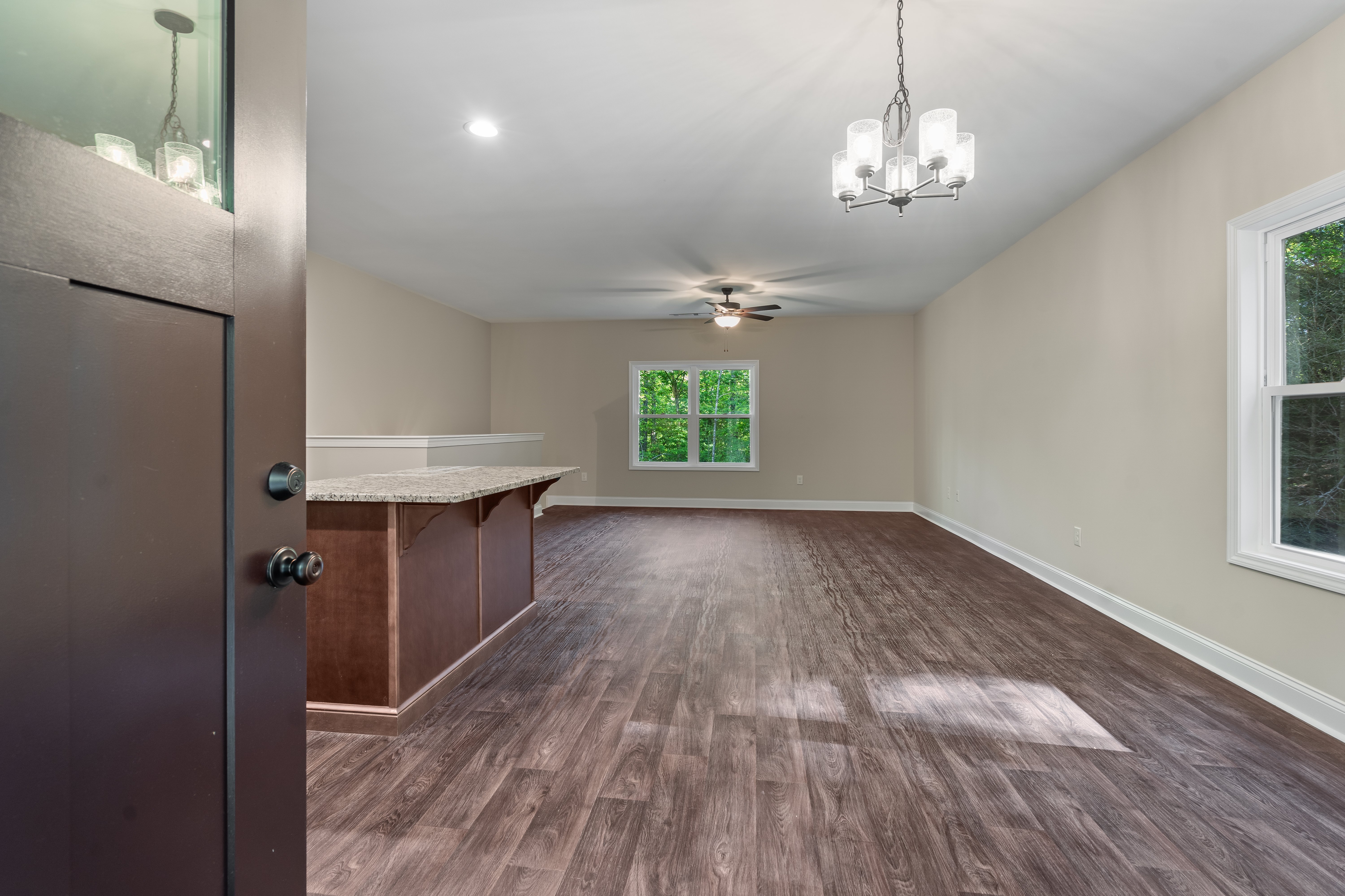 Open concept kitchen and living room with vaulted ceilings and hardwood floors