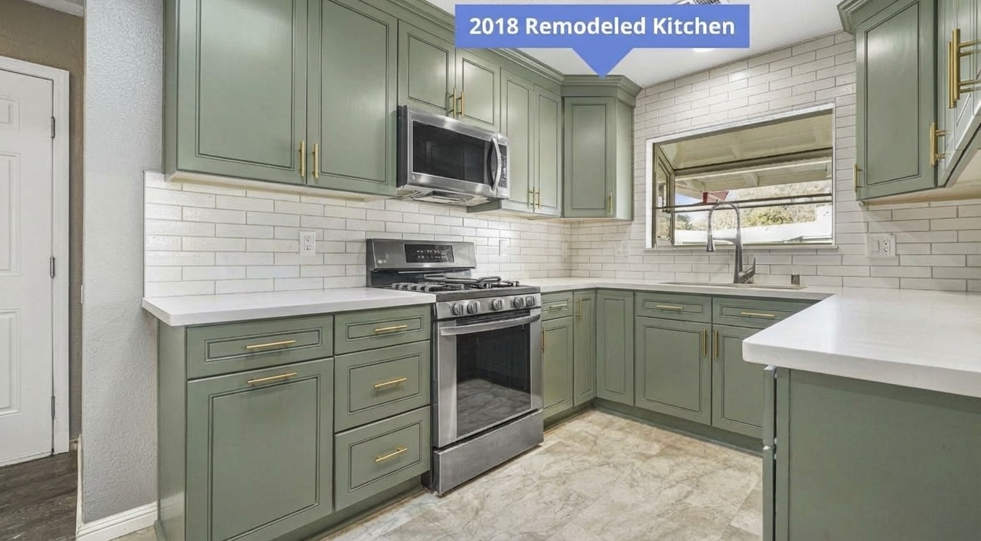 Sage green cabinets with brushed brass hardware against white subway tile