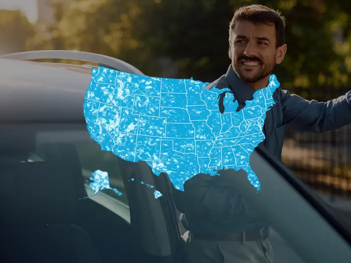 Man standing next to a car with an illustrated US map overlay showing nationwide service coverage