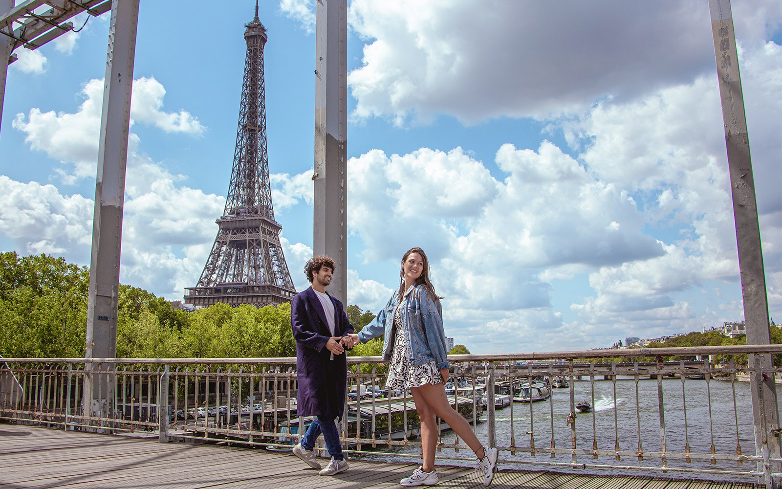 Cặp đôi tạo dáng trên một cây cầu với Tháp Eiffel ở phía sau, Paris.