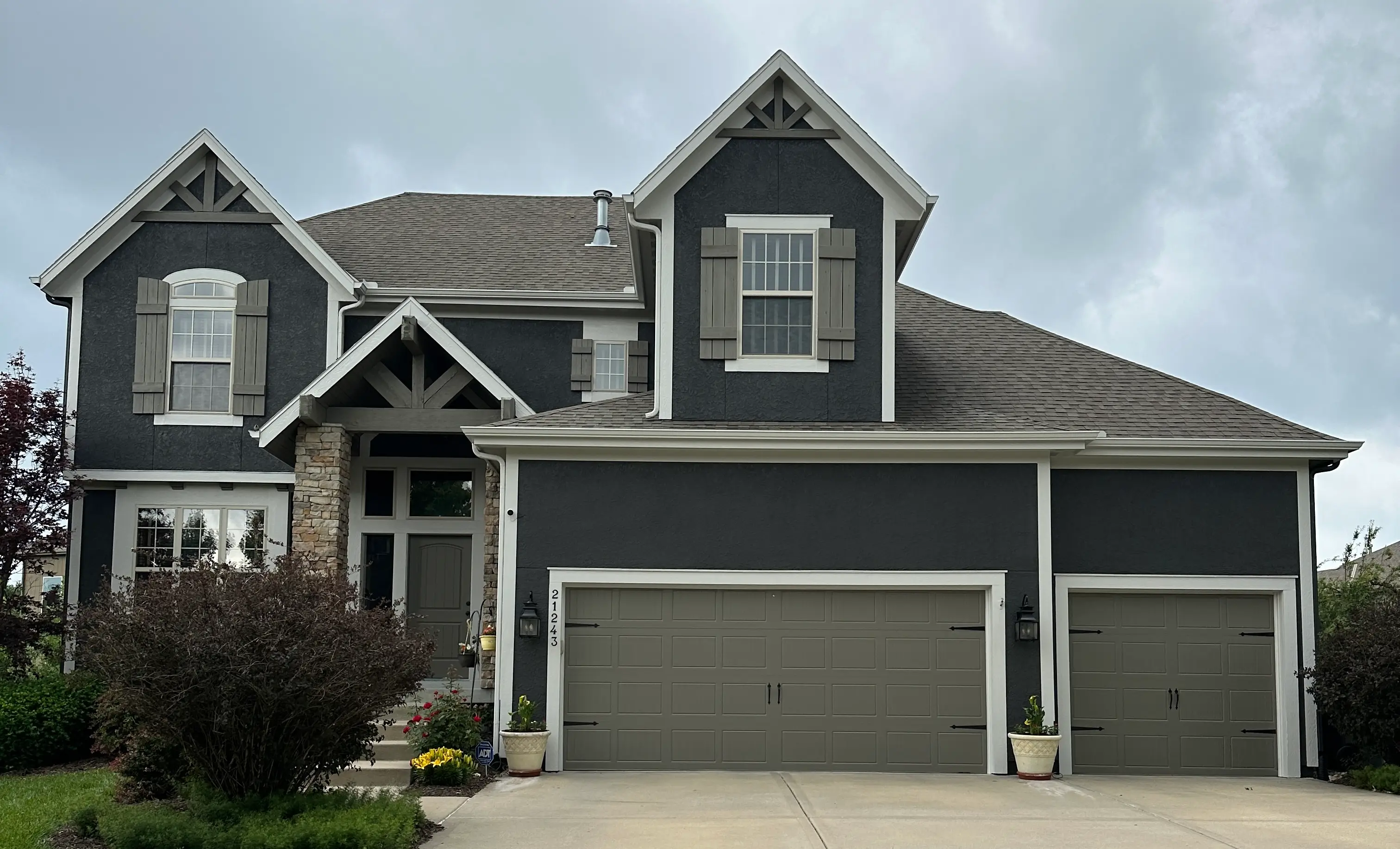 An image of a dark grey house with light grey trim.