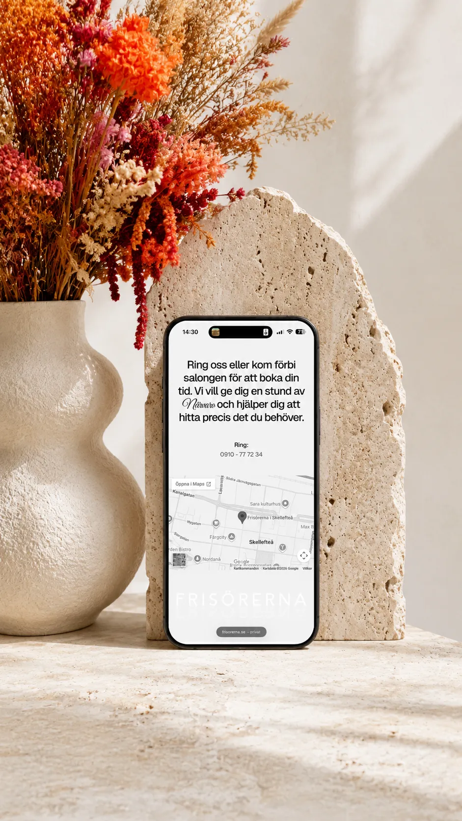 iPhone displaying the Frisörerna contact page and Skellefteå map, styled with colourful dried flowers and travertine.