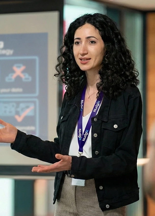 Product design strategist presenting to founders on how to transform complex technology into an investable asset for pre-seed and seed fundraising. The presentation slide, titled 'Founders: Stop Guessing,' focuses on defining a north star and mapping data to improve UX/UI strategy and prepare the MVP for investors