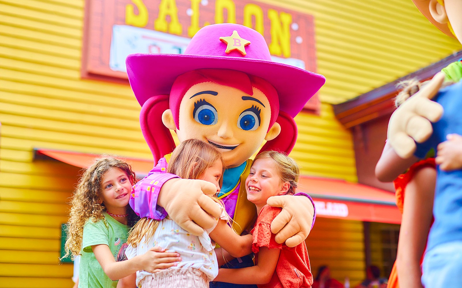 Gyerekek ölelik a Bobbejaanland vidámpark kabalafiguráját.