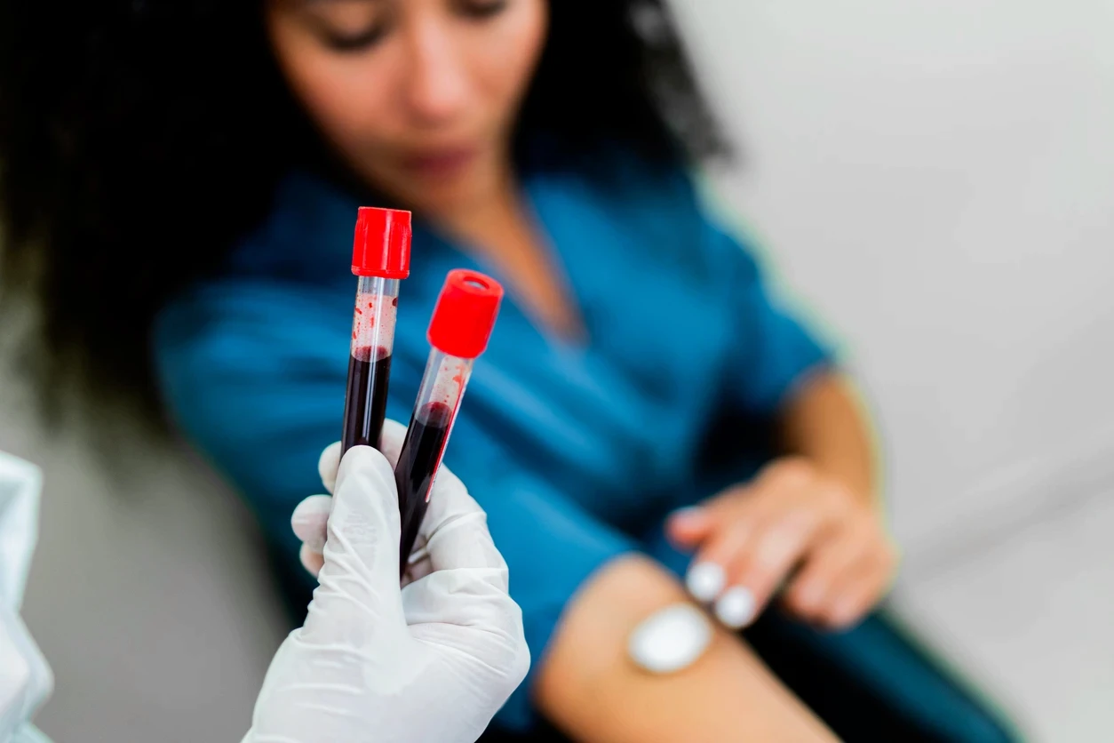 Profissional segurando tubos de sangue para exame laboratorial