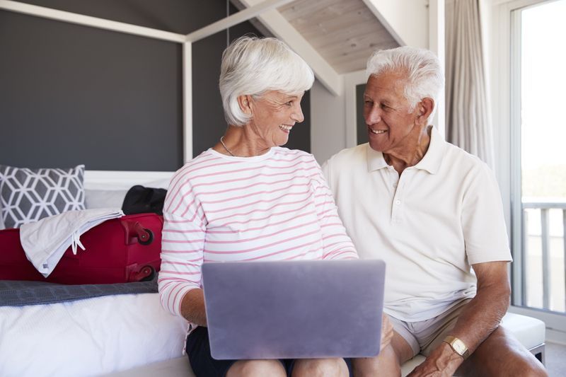 Senior seated in bed with laptop