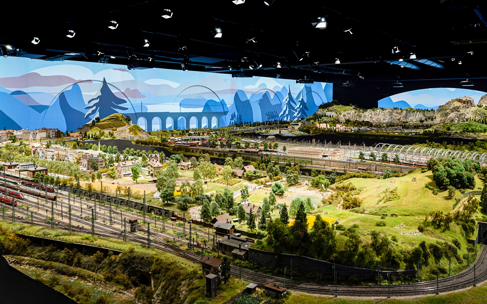 Paesaggio ferroviario in miniatura a Hzero, caratterizzato da modellini di treni dettagliati e panoramiche campagne.