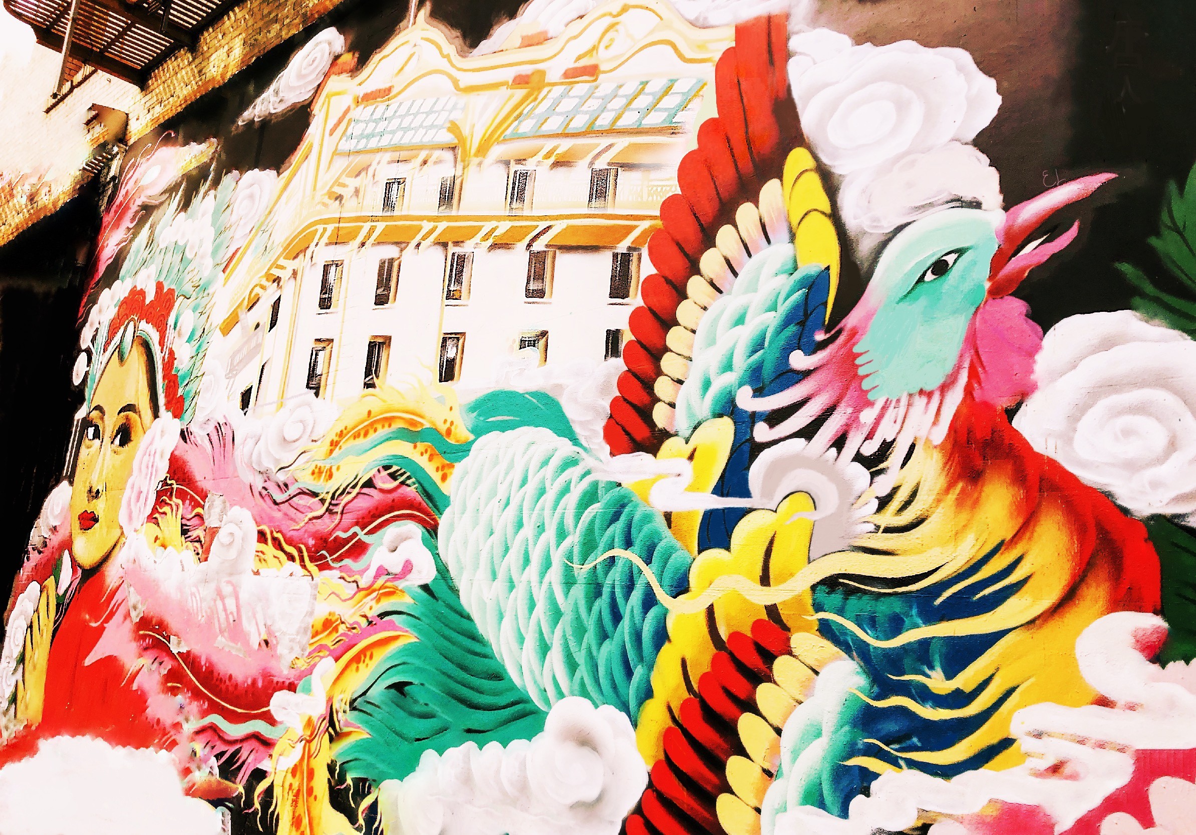 A restored photograph of a colorful San Francisco mural, displaying a woman and bird.