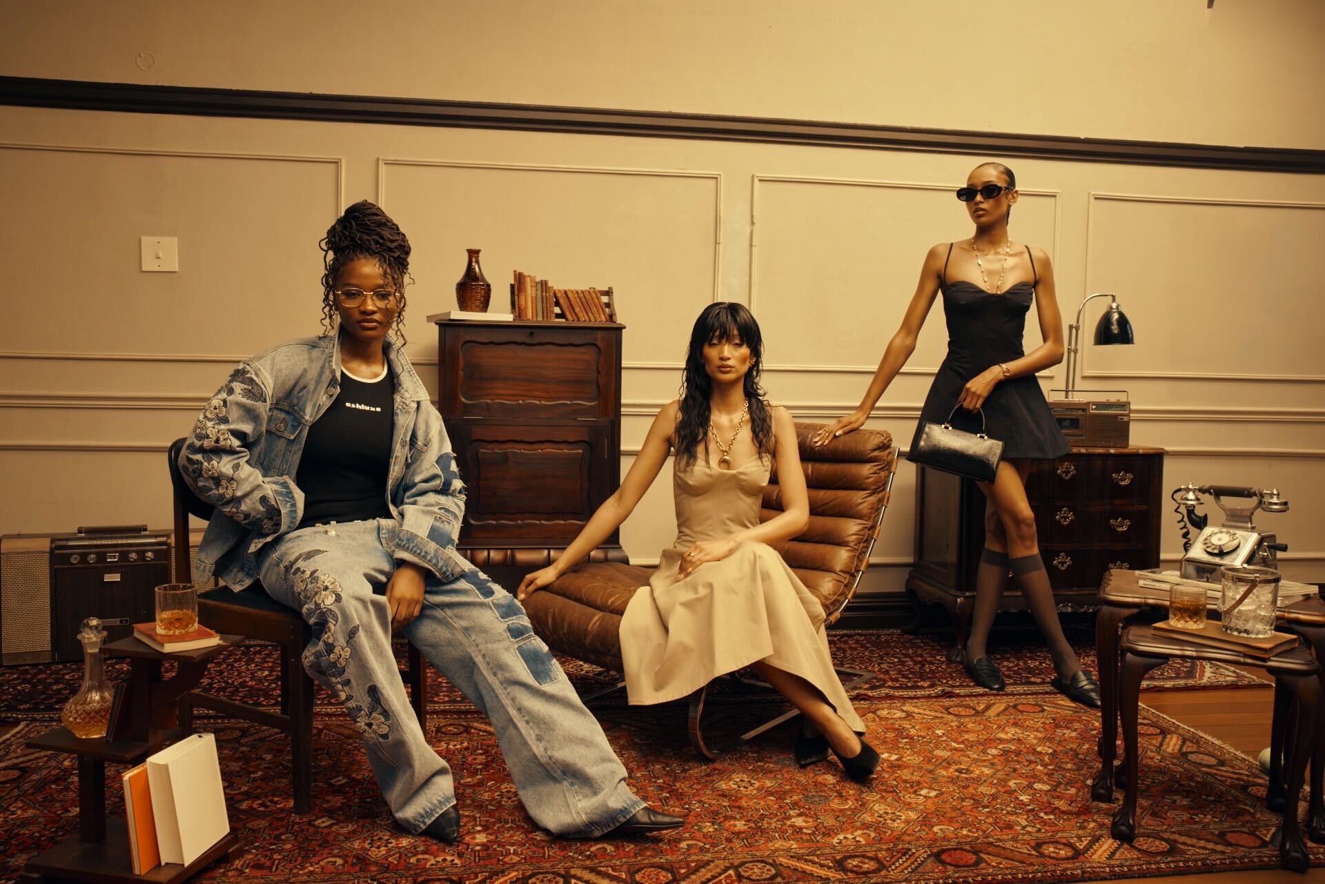 Fashion models posing in stylish ash luxe clothing with warm orange ambiance lighting.