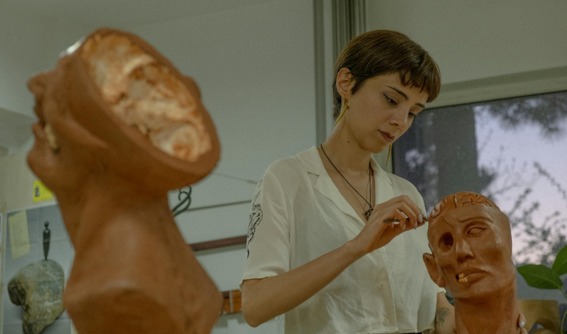 Close-up of a student's hands manipulating a 3D anatomical brain model to understand how tactile learning works.