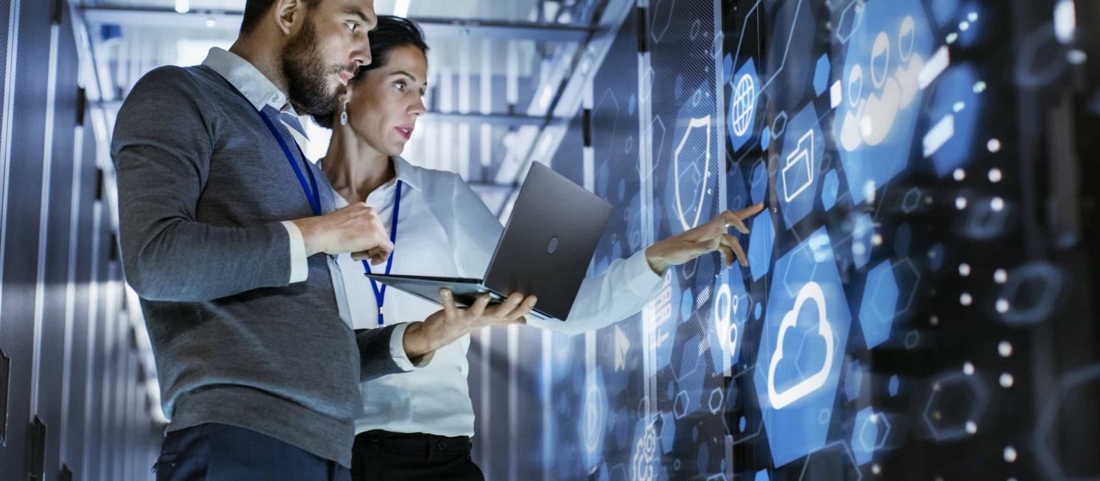 A modern glass building sits in front of a snow capped mountain.