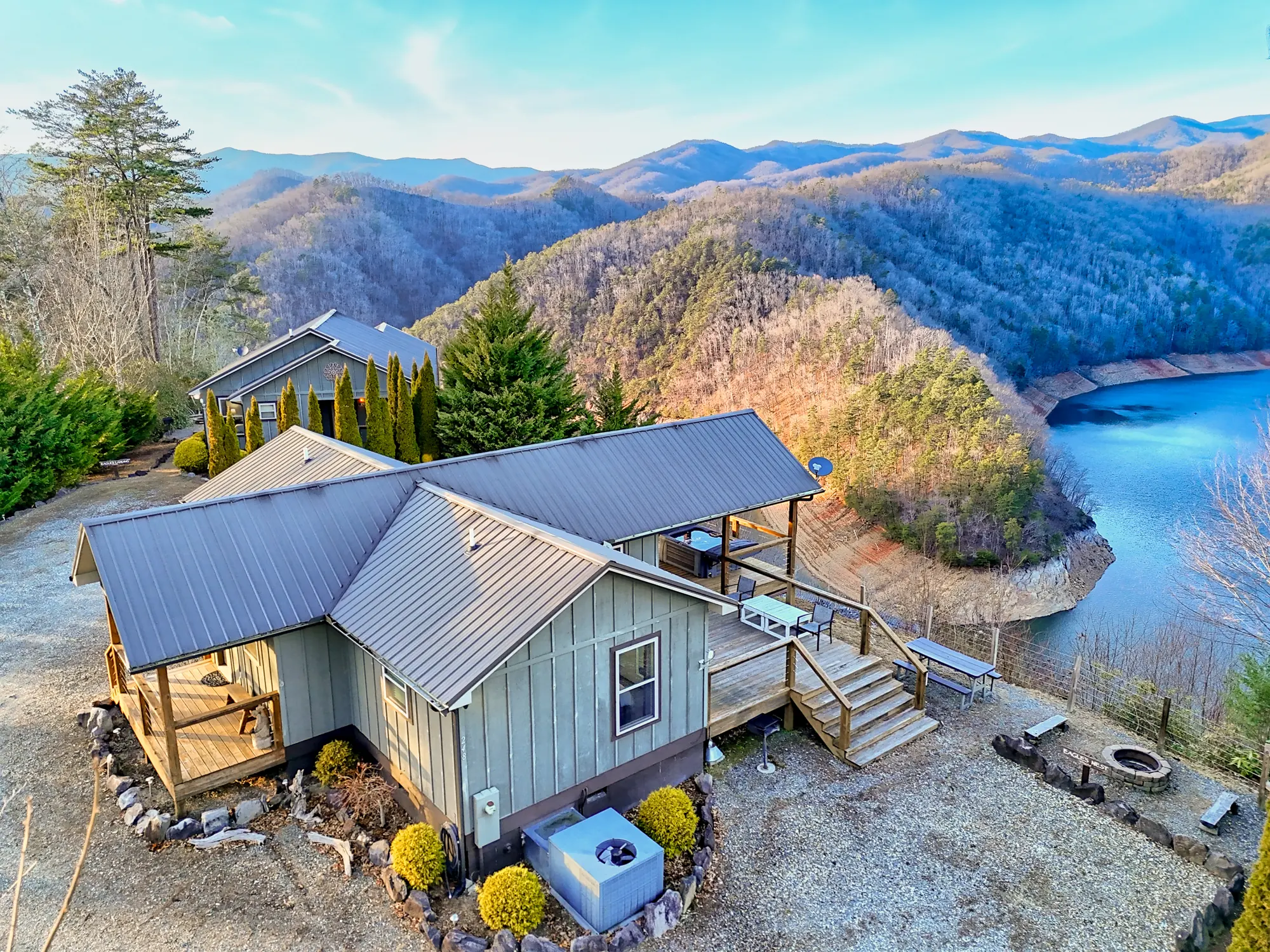 Aerial view of Eagles Nest, a gray metal-roof cabin on a ridge above a bend of Fontana Lake