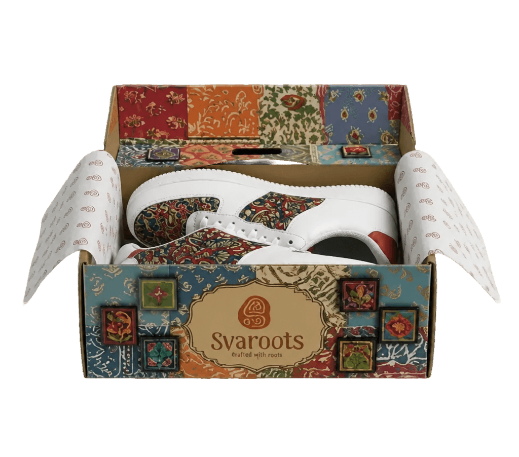 An open Svaroots shoebox showing a red patterned sneaker inside