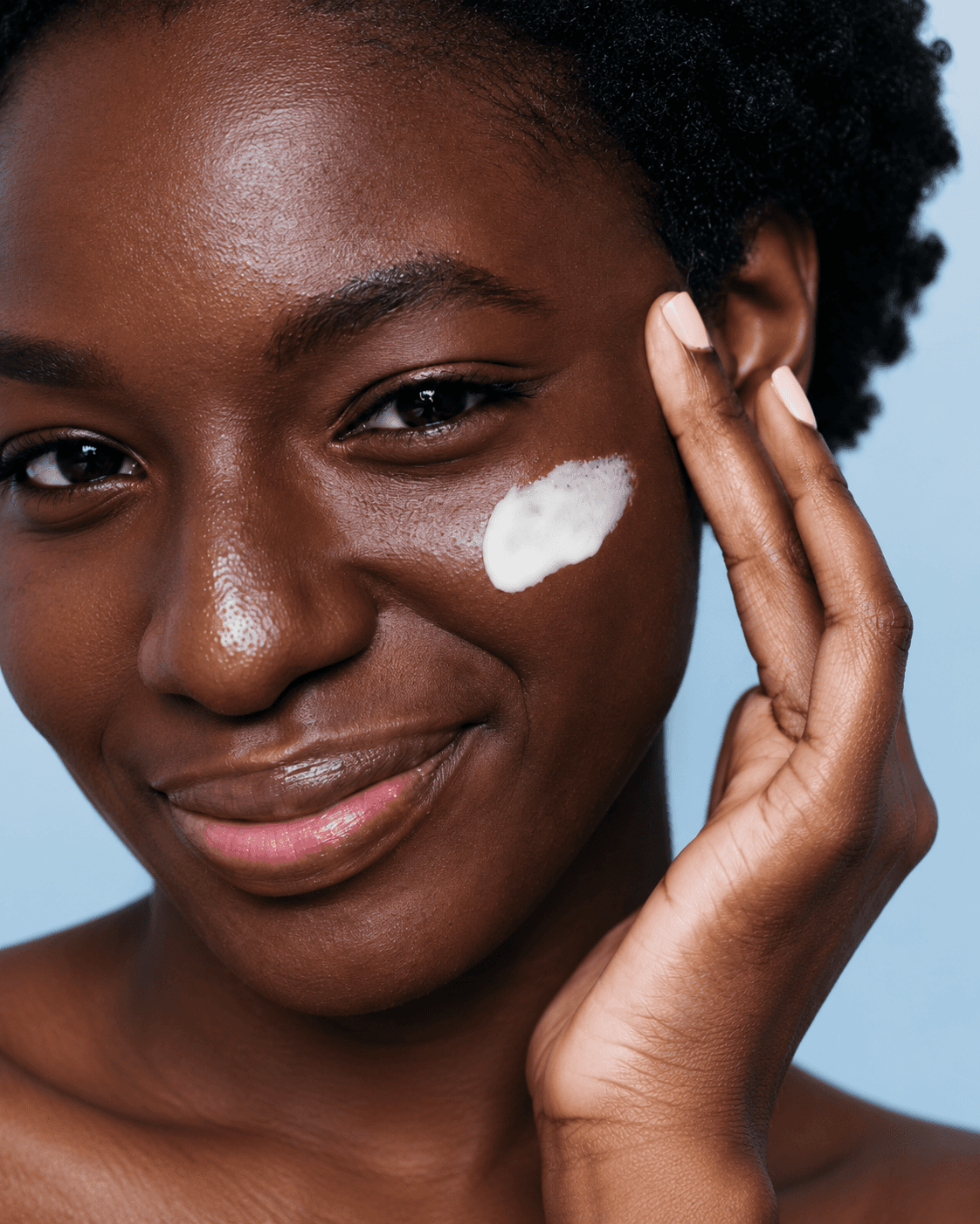 Skincare portrait with cream on her cheek
