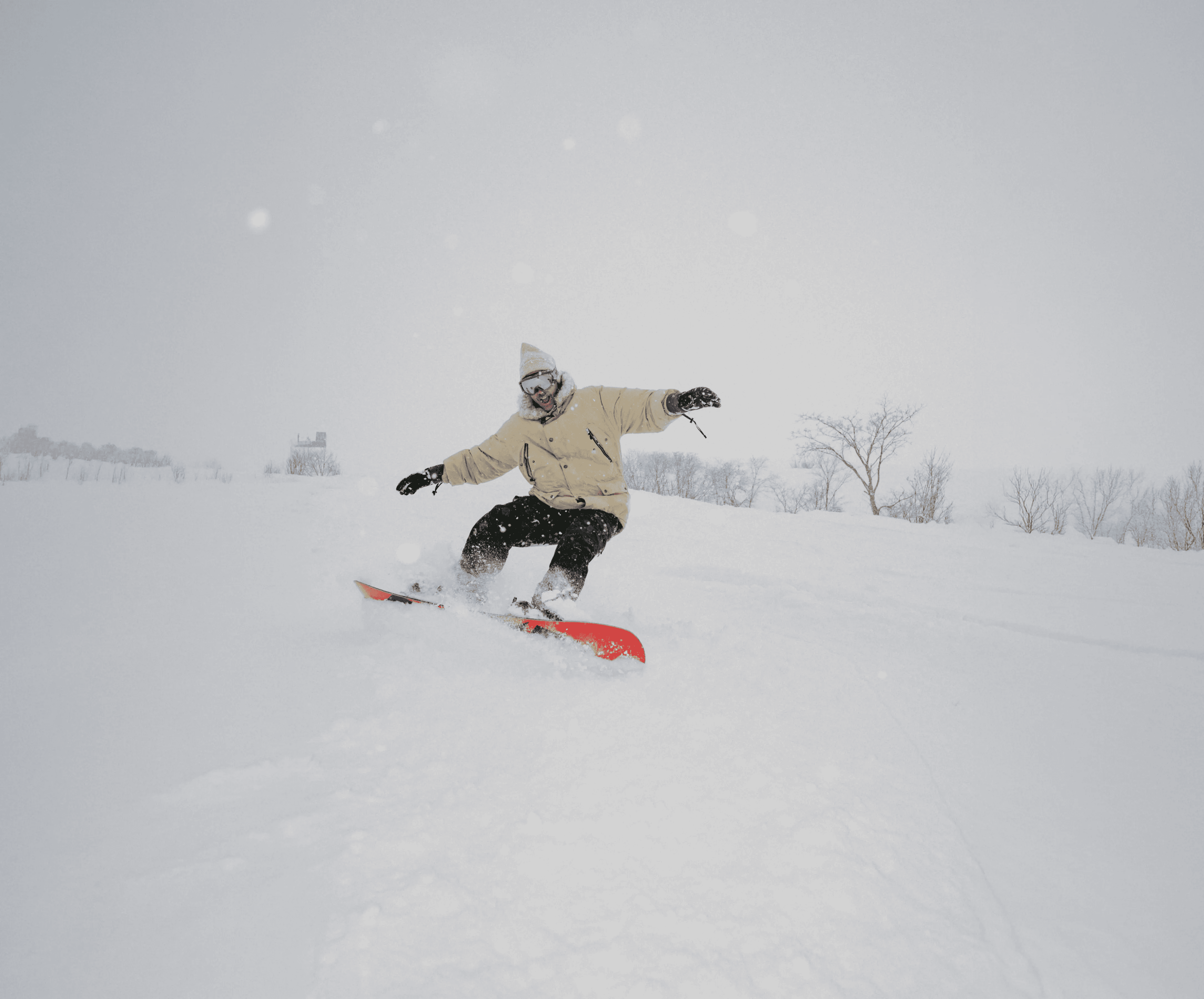 A snowboarder carving through fresh powder, Snow Machine Japan brand photography