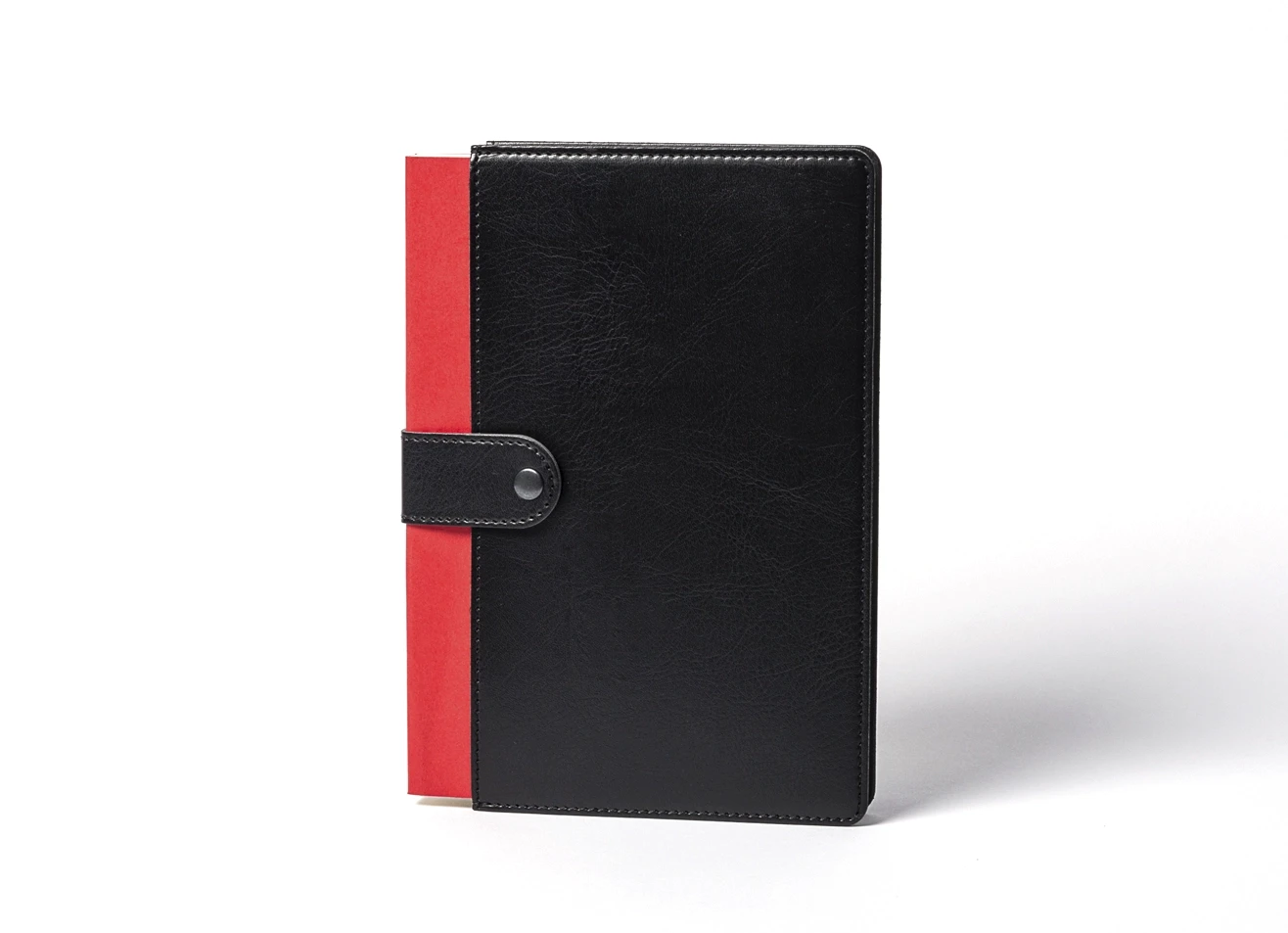 Front view of standing black notebook with red spine accent.