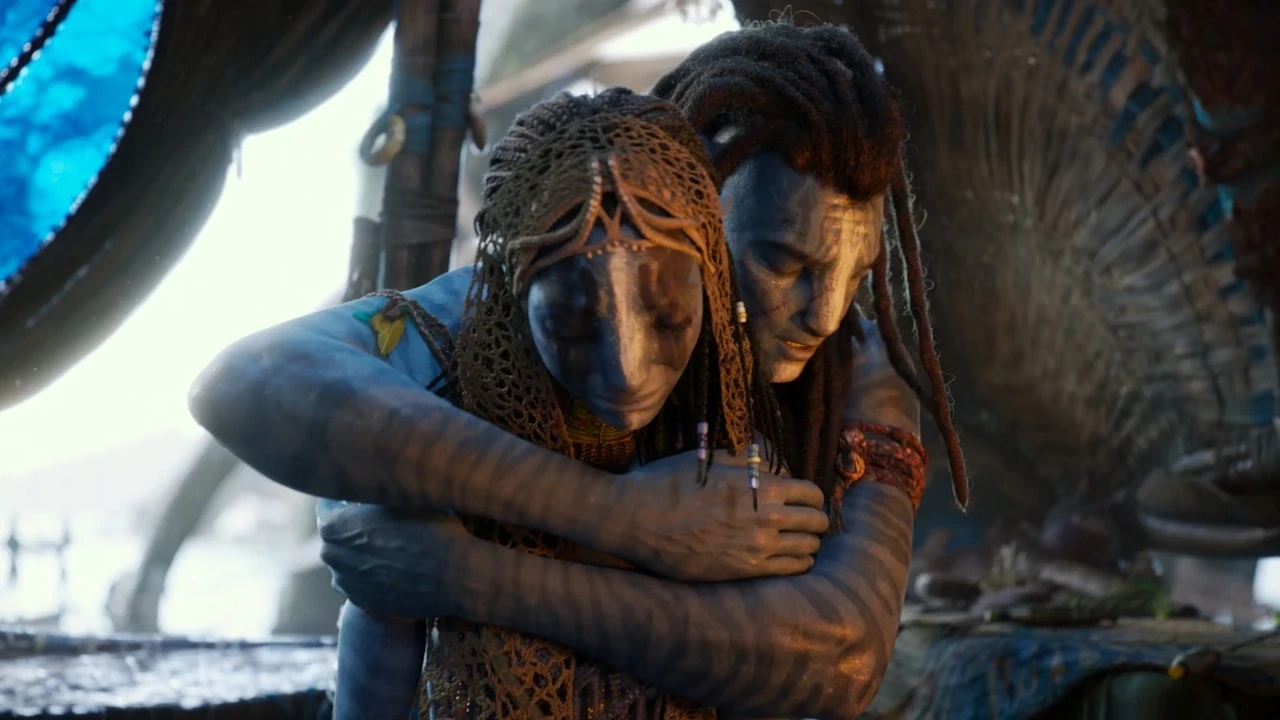 Two figures with blue skin, adorned in intricate woven garments and accessories, share an intimate embrace against a blurred natural background, evoking a scene of connection and emotion.