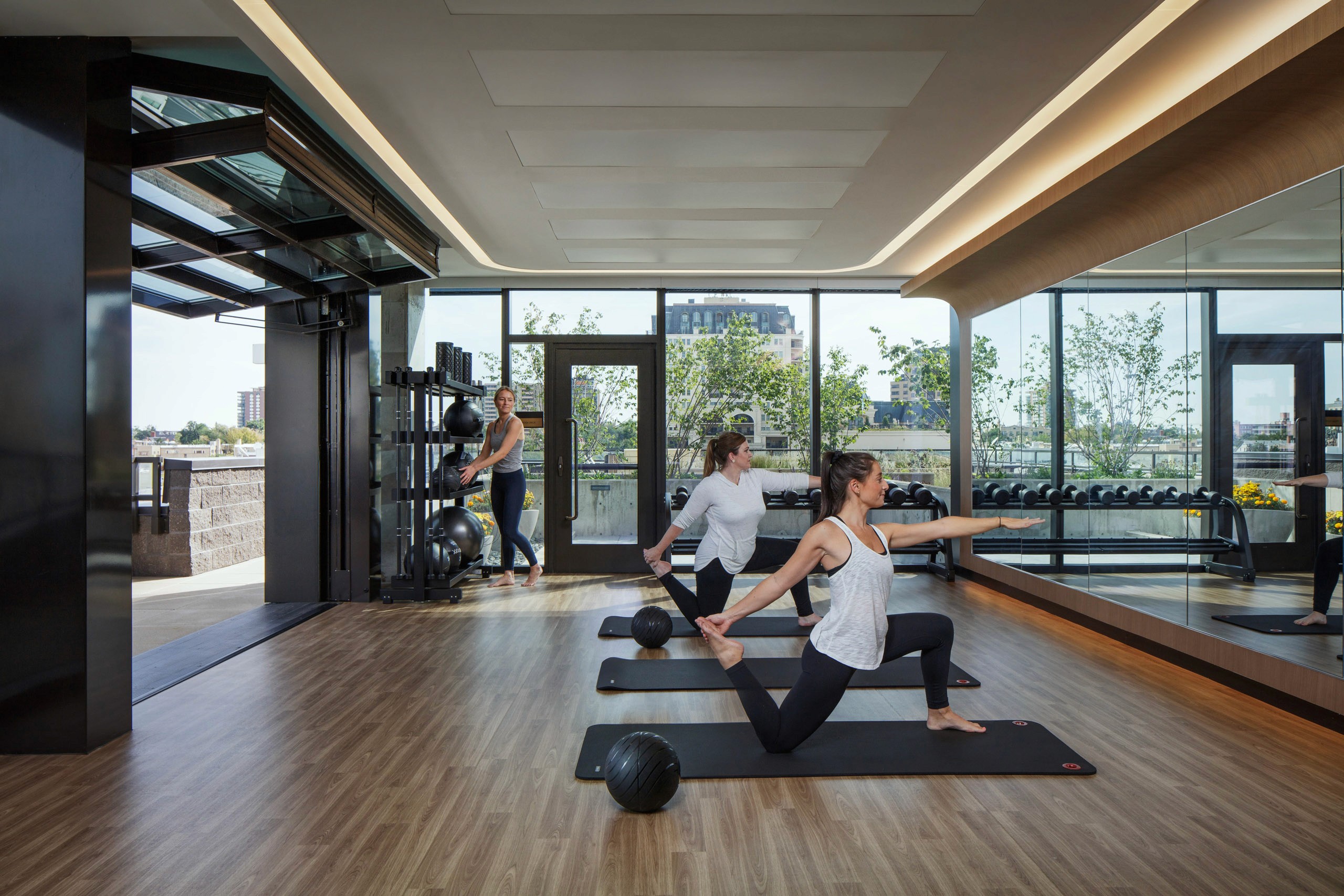 Women practicing yoga in a modern gym.