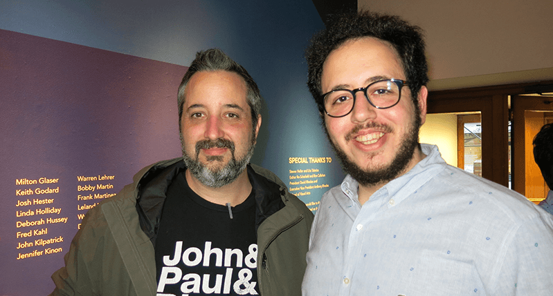 A photo of two men standing in an exhibition room.