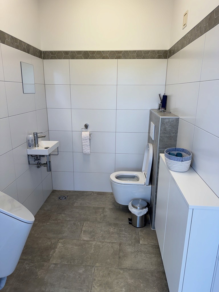 WC mit Waschbecken und gefliestem Boden