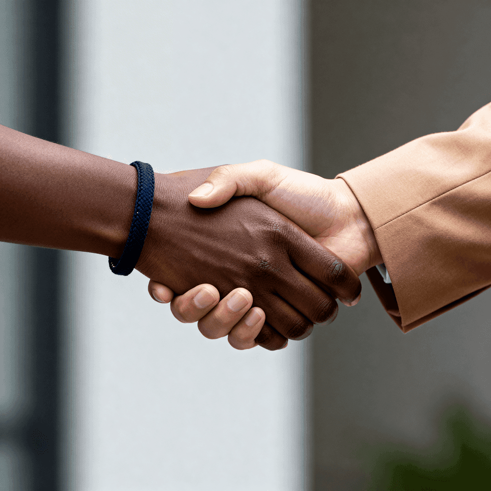 Aperto de mão entre duas pessoas, representando parceria e negócios com o setor público.