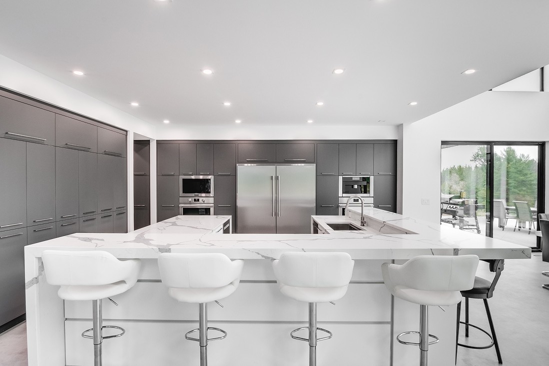 White kitchen with double islands and ceiling spotlights