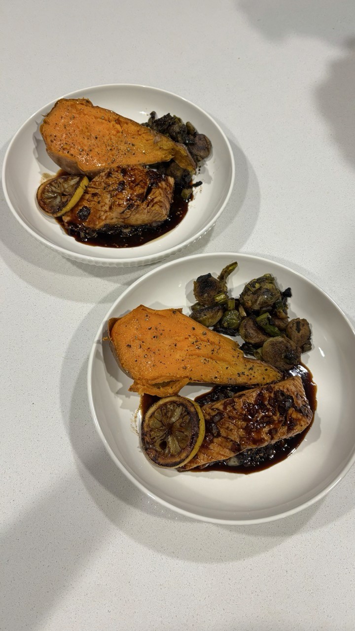 Two plates with baked salmon, roasted sweet potato and Brussels sprouts – healthy weeknight salmon dinner Wellness by Suhey
