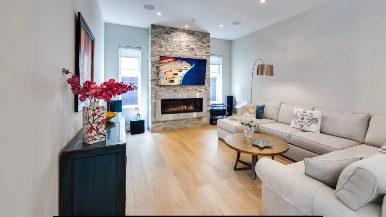 Modern living room with floor-to-ceiling natural stone fireplace, linear gas insert, built-in entertainment center, and comfortable seating in Vancouver custom home