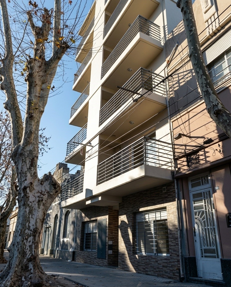 Frente de edificio de departamentos con balcones de rejas de hierro, revestimiento blanco, Edificio Parin I, Rosario