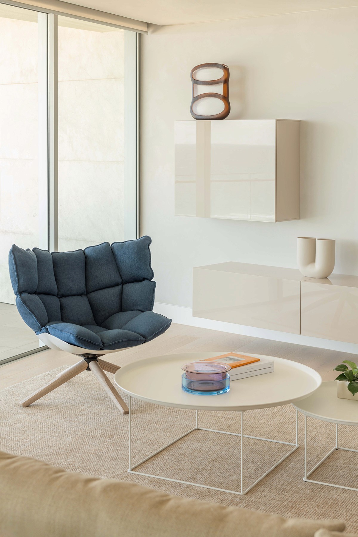 High Tide apartment living area with sculptural lounge chair, minimalist furniture, and soft coastal palette in Surfers Paradise.