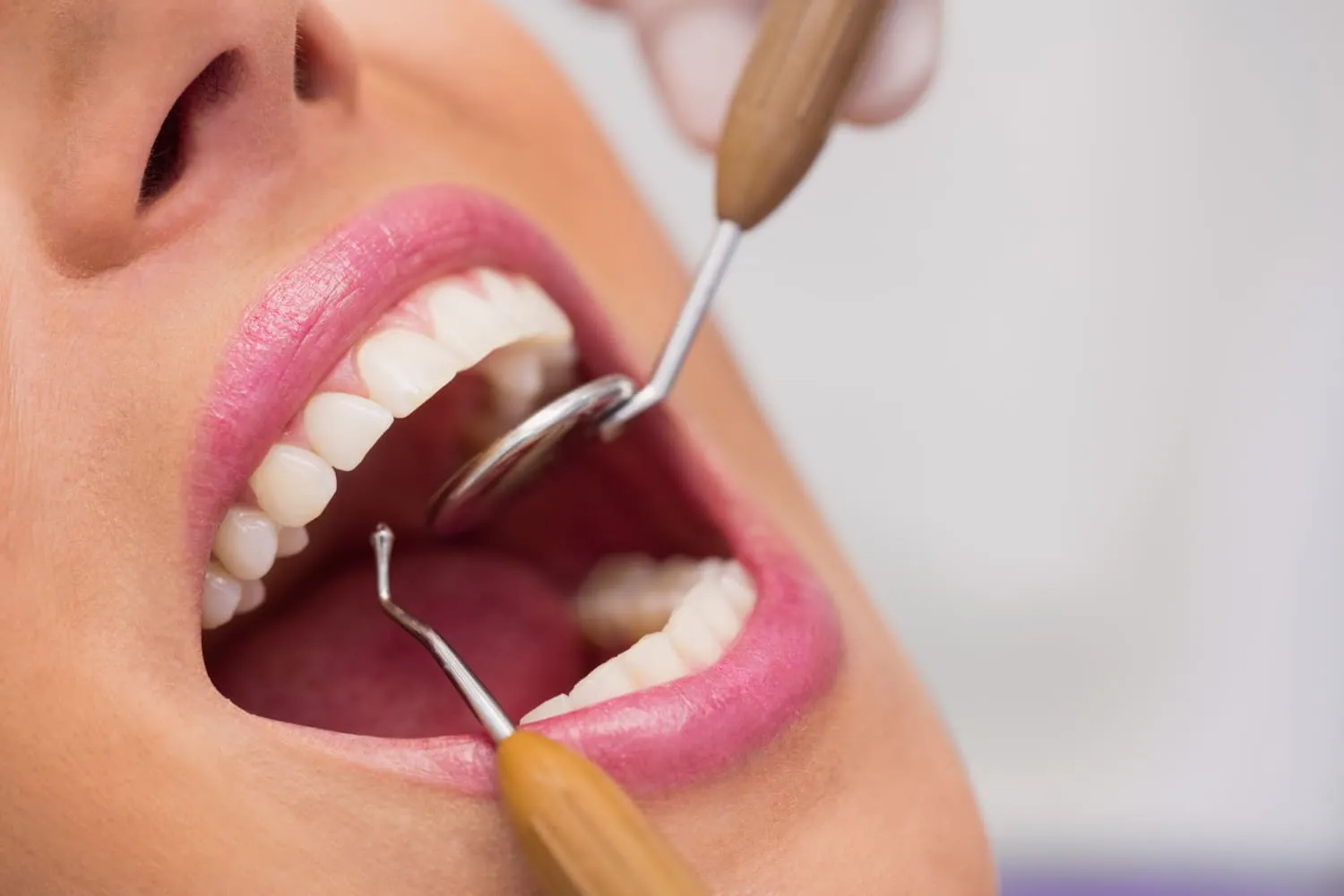 Open mouth with dental tools.