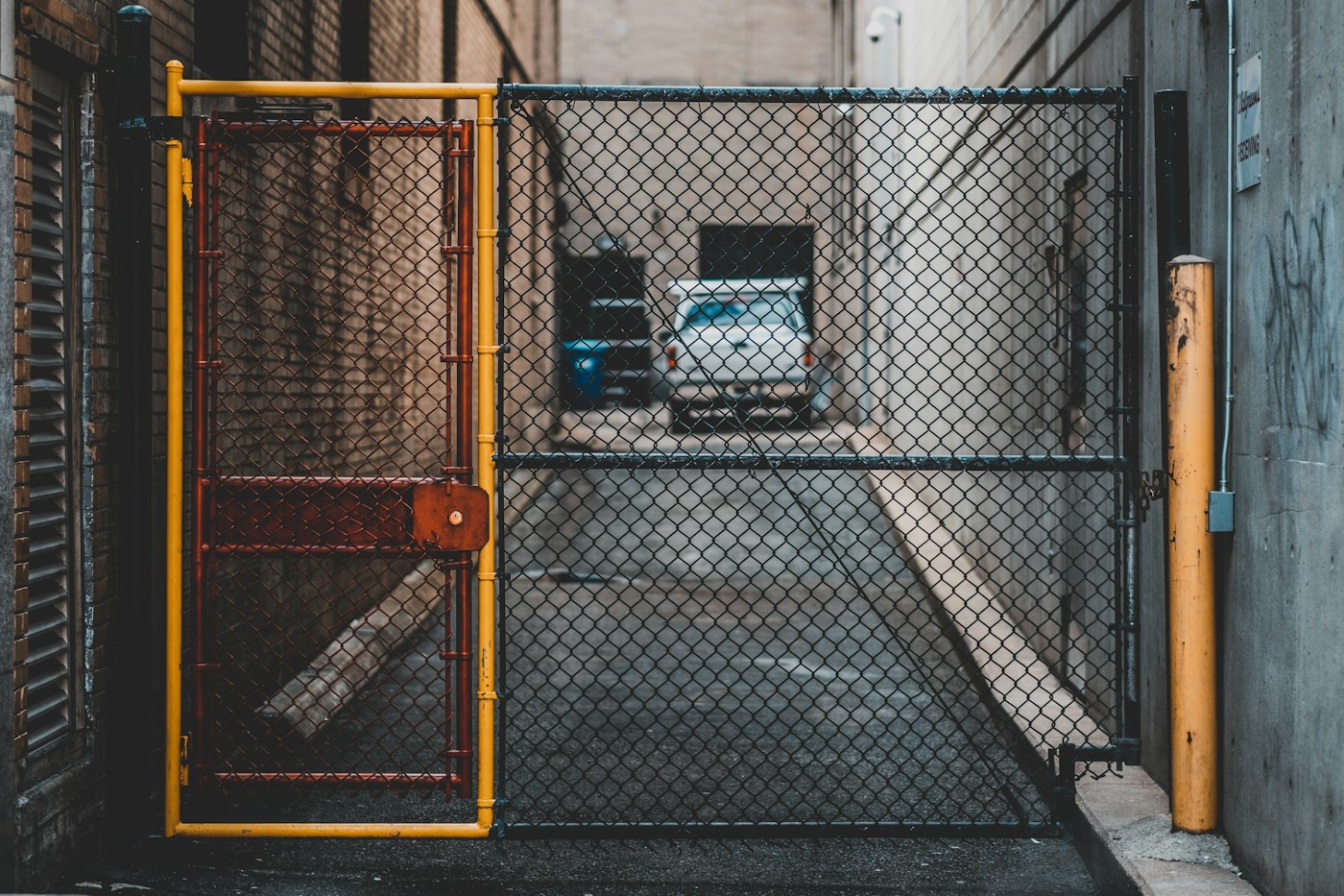 Yellow and black metal gate at the entrance of a fenced facility